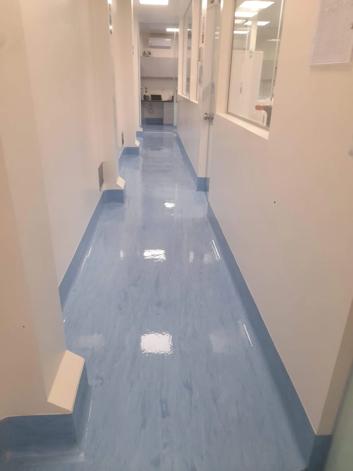 Pasillo clínico · piso vinílico azul